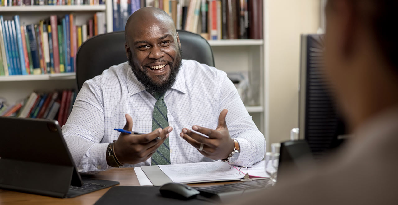 Professor meeting with students in his office.