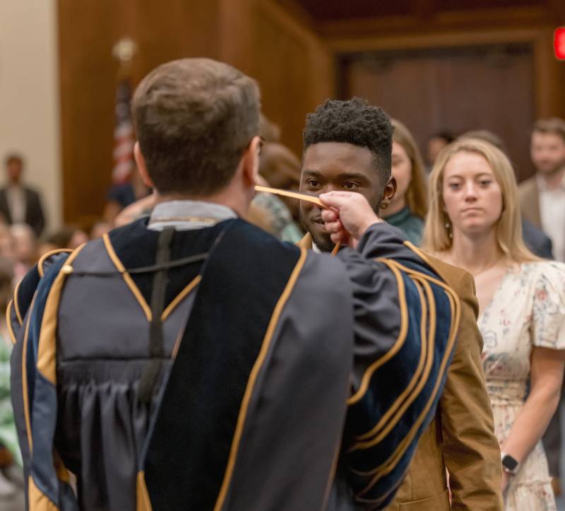 MC President Blake Thompson presents medals to senior Honors College students Xavian Branch and Kayleigh Canoy during the 2025 Honors Convocation.